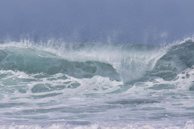 Water splashing in sea against sky