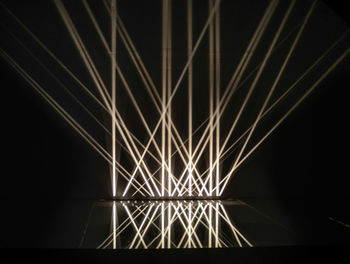 Low angle view of illuminated lights against sky at night