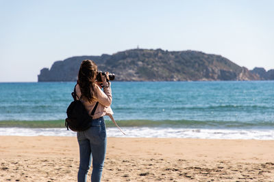 Woman standing on beach against sea