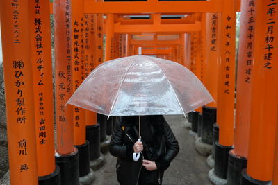 Rear view of man holding cross in rain