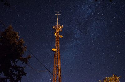 Low angle view of electricity pylon against sky at night