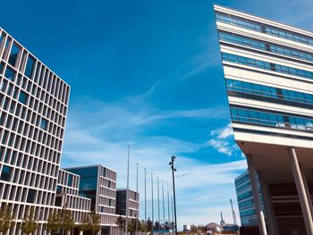 Low angle view of modern buildings against blue sky