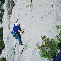 High angle view of man climbing on rocky mountain