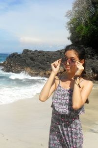 Teenage girl wearing sunglasses standing at beach