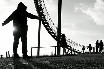 Silhouette people at tiger and turtle  magic mountain against sky