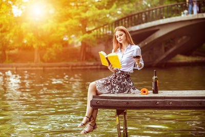 Portrait of woman sitting by lake