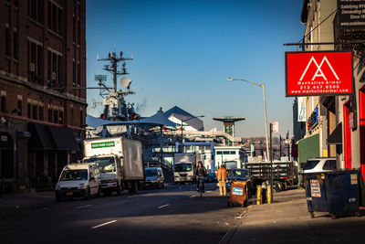 Road sign on street in city against clear sky