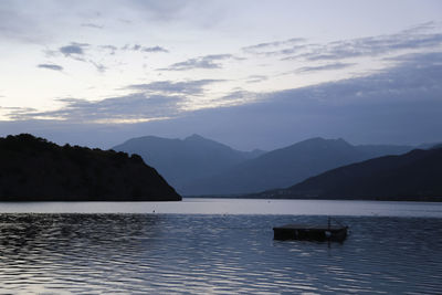 Scenic view of lake by mountains against sky