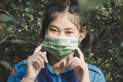 Portrait of girl holding plant