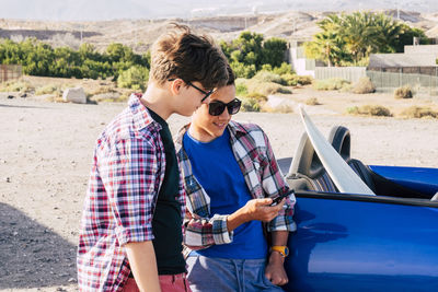 Young couple sitting on car