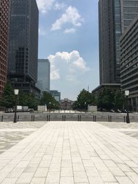 Street by buildings against sky in city