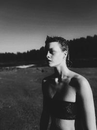 Portrait of young woman standing against sky at night