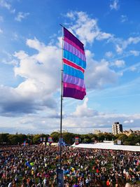 Group of flags on the beach against sky