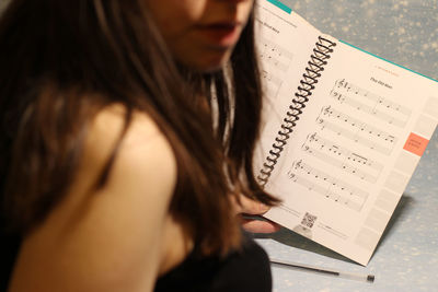 Midsection of woman holding musical notes