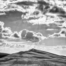 Scenic view of mountains against cloudy sky