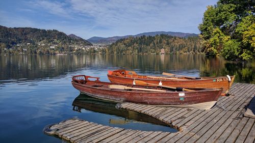 Boats moored on lake against sky