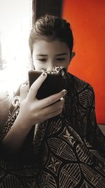 Midsection of girl using mobile phone