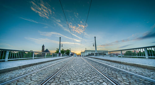 Railroad tracks against sky at sunset