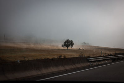 Road amidst field against clear sky