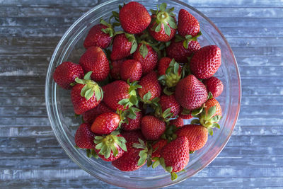 Strawberries on bowl on  blue wooden table