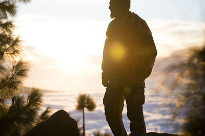 Low angle view of man standing against sky during sunset