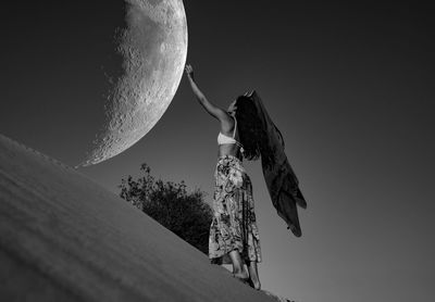 A girl touching the moon