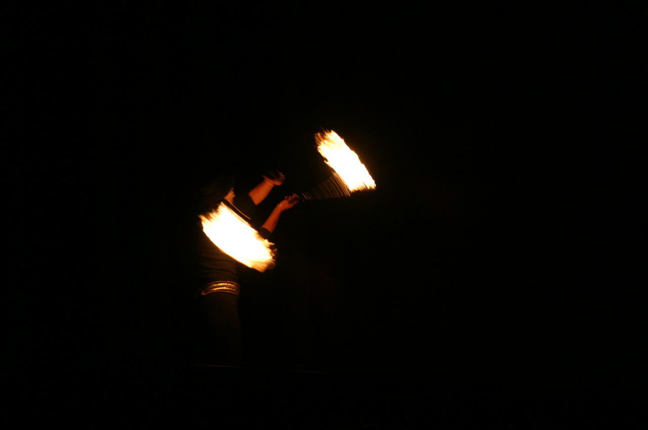 PERSON HOLDING BURNING CANDLE IN DARK