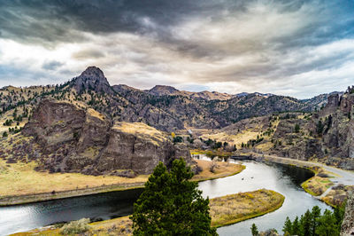 Scenic view of river by mountains against sky