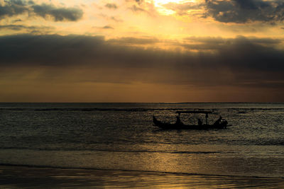 Silhouette boat in sea against sky during sunset