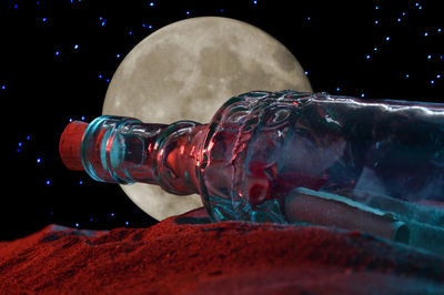 Digital composite image of glass bottle against black background