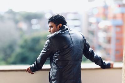 Side view of young man looking away outdoors