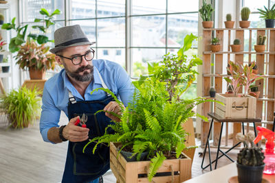 Man standing by potted plants