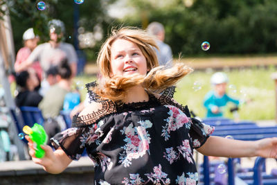 Woman playing amidst bubbles at park