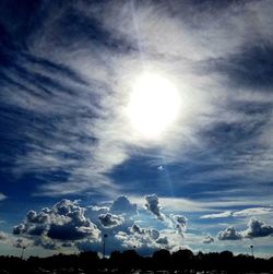 Low angle view of bright sun in sky