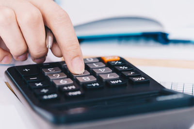 Close-up of person using smart phone on table