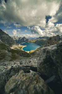 Rocks by lake against sky