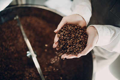 Close-up of hand holding coffee beans