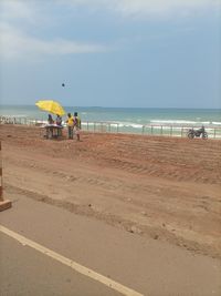 People at beach against sky