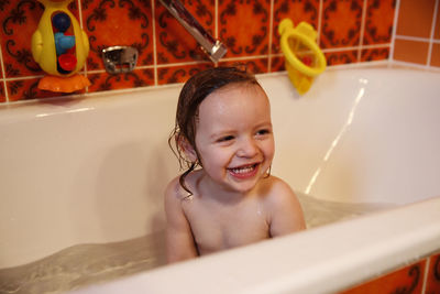 Happy girl in bathtub at home