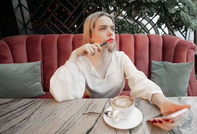 Portrait of young woman sitting on table