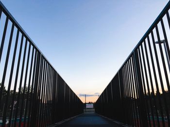 Empty footbridge against clear sky