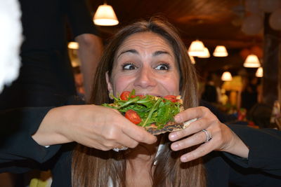 Close-up of woman eating open sandwich in restaurant