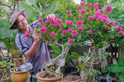 Woman standing by potted plants