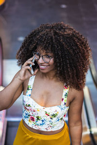 Portrait of smiling young woman holding smart phone