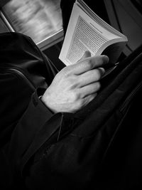 Midsection of man reading book
