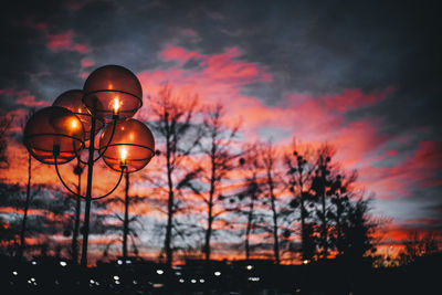 Low angle view of illuminated street light against sky at sunset