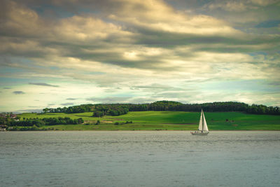 Sailboat sailing on sea against sky