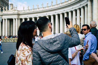 Rear view of man and woman using mobile phone