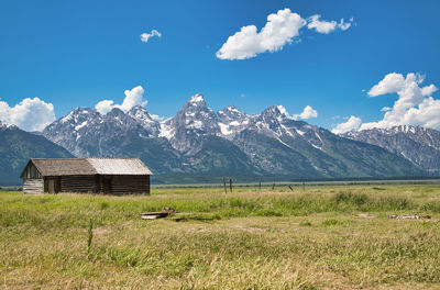 Scenic view of field and mountains against sky