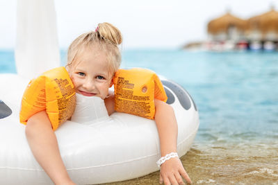 Portrait of smiling girl with inflatable in sea